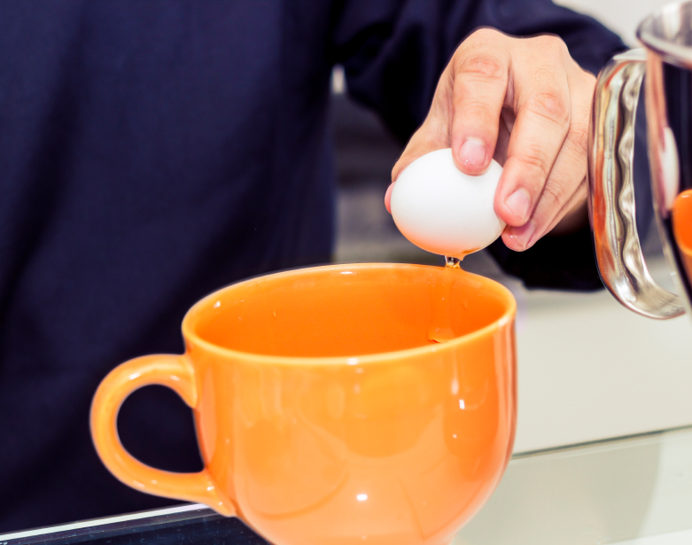 breaking egg in mug