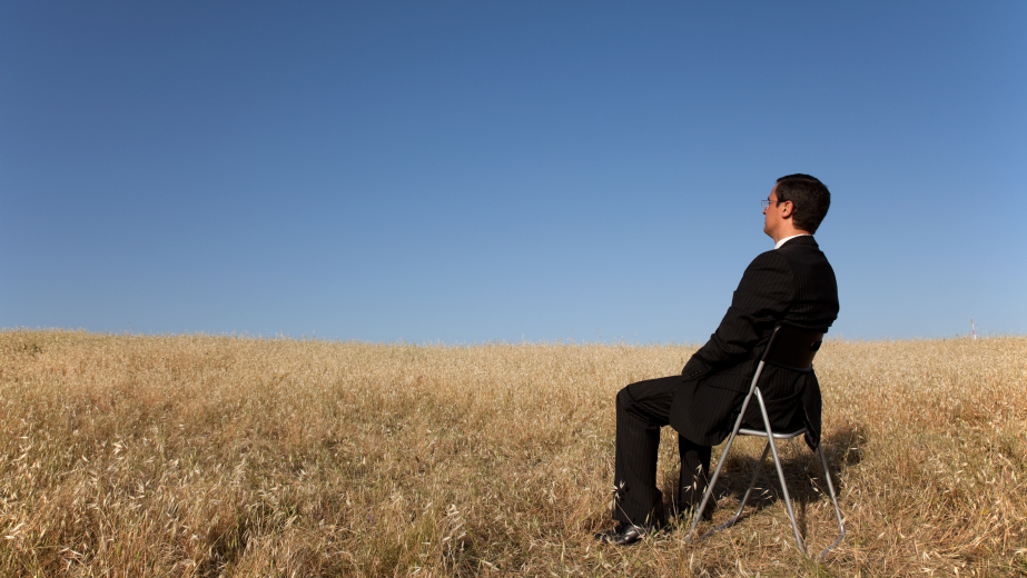 Man sitting in a cornfield in a suit