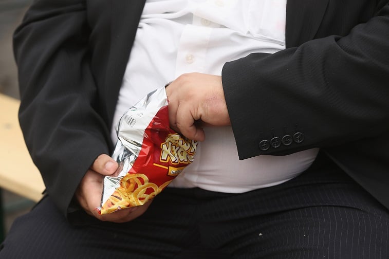 A man eating a bag of chips
