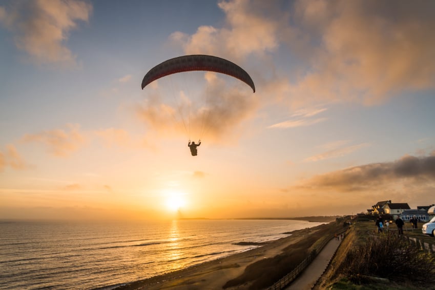 Paraglider flying over beach