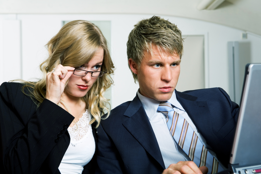 man and woman looking at computer