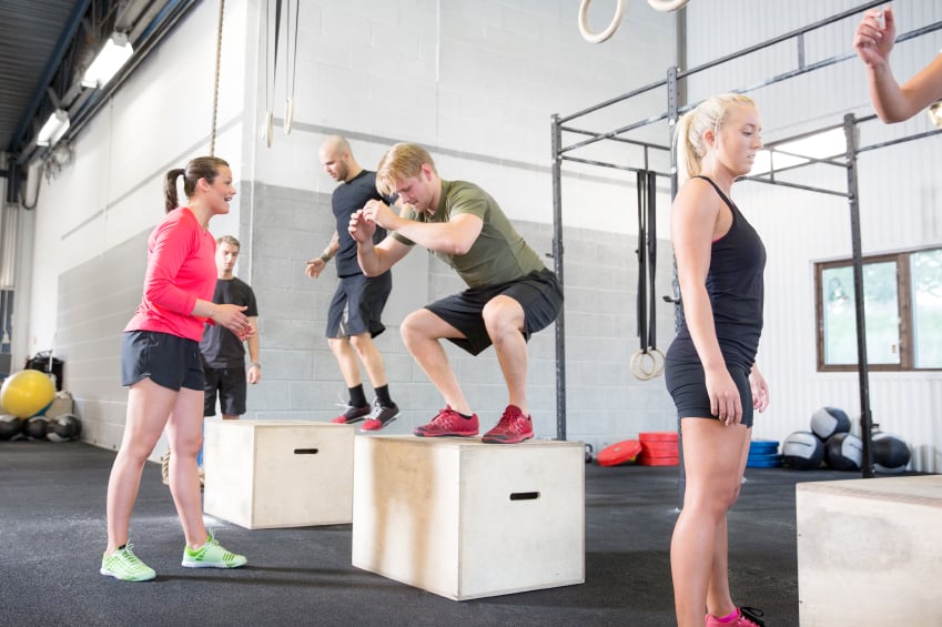 people doing box jumps in a gym people doing box jumps in a gym