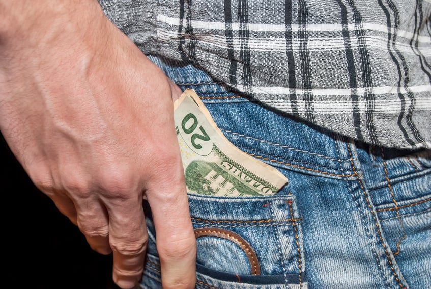man putting cash in pocket