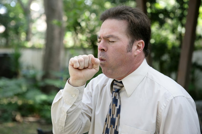 man coughing as he stands outside man coughing as he stands outside