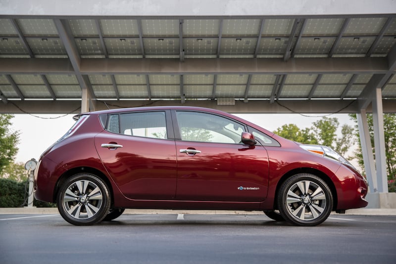 Side view from passenger side of red 2016 Nissan Leaf