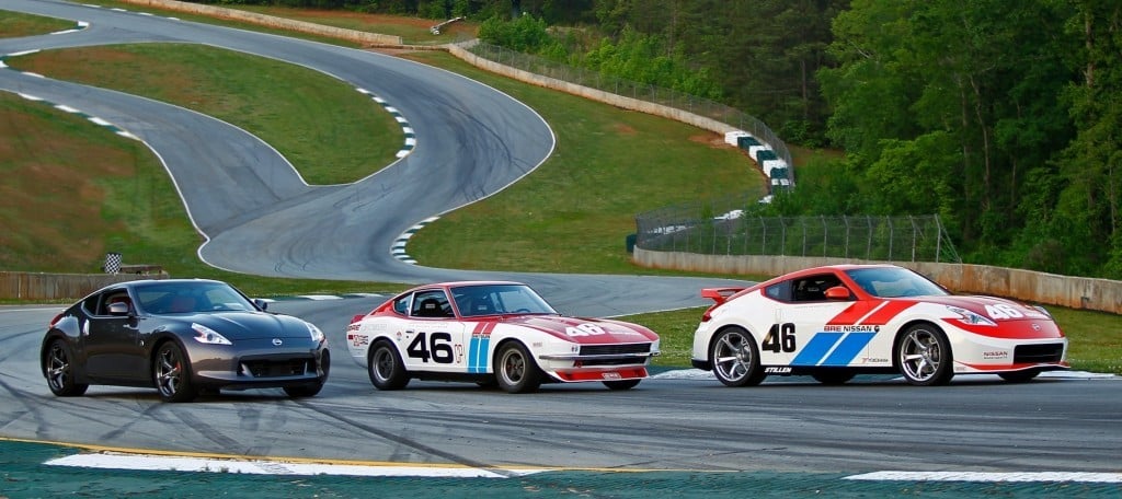 A Datsun 240Z and Nissan 370Z parked on a race track.