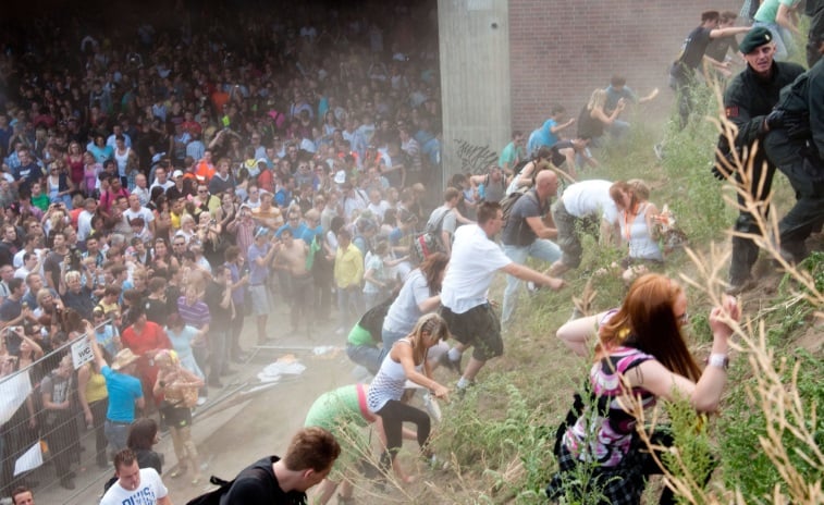 A group of people from the Love Parade are running uphill.