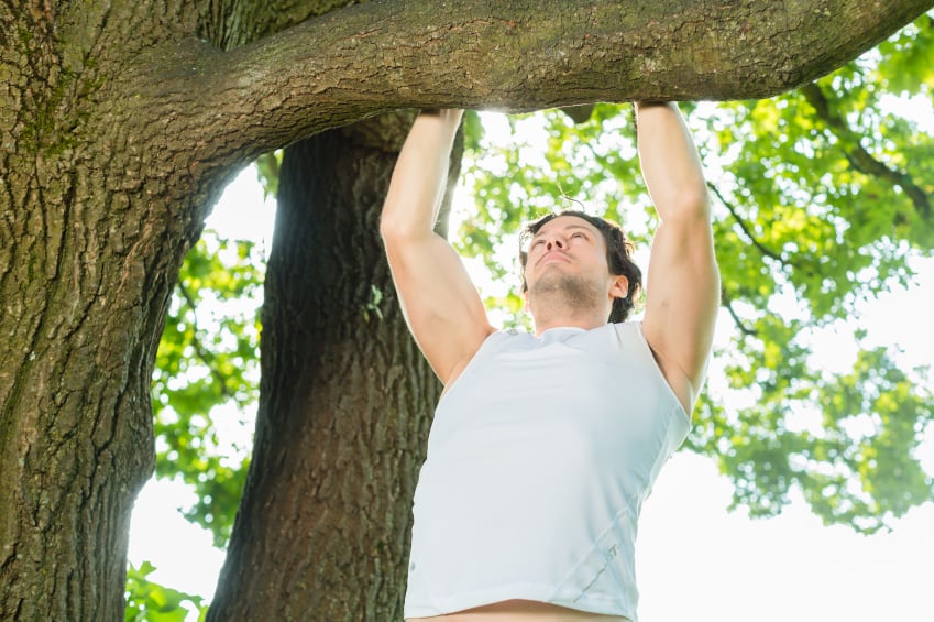 Man doing chin-ups outside Man doing chin-ups outside