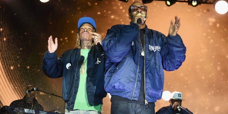 Snoop Dogg and Wiz Khalifa are rapping next to each other on stage.