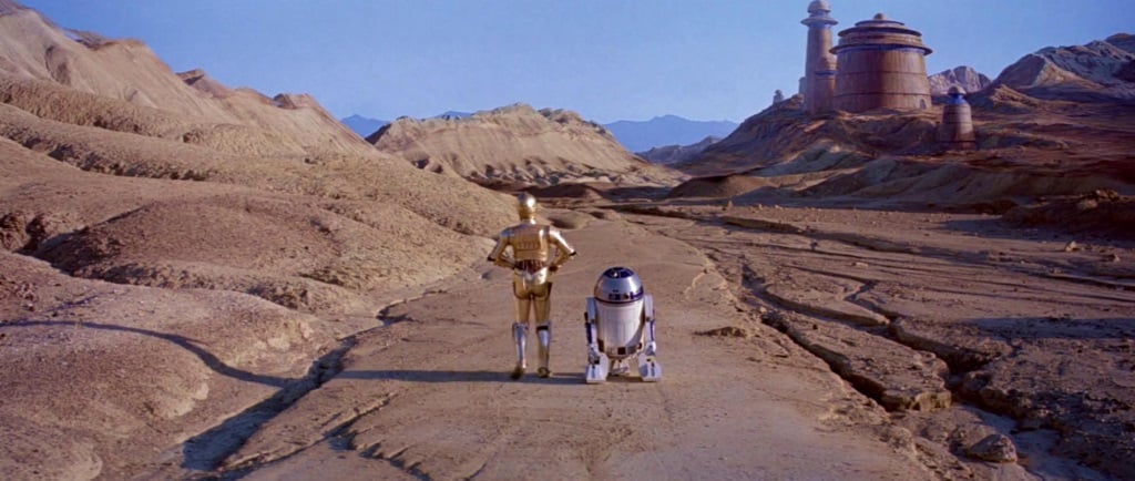  C-3PO and R2-D2 stand side by side on a deserted road