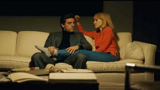 Oscar Isaac and Jessica Chastain sit together on a. couch in A Most Violent Year