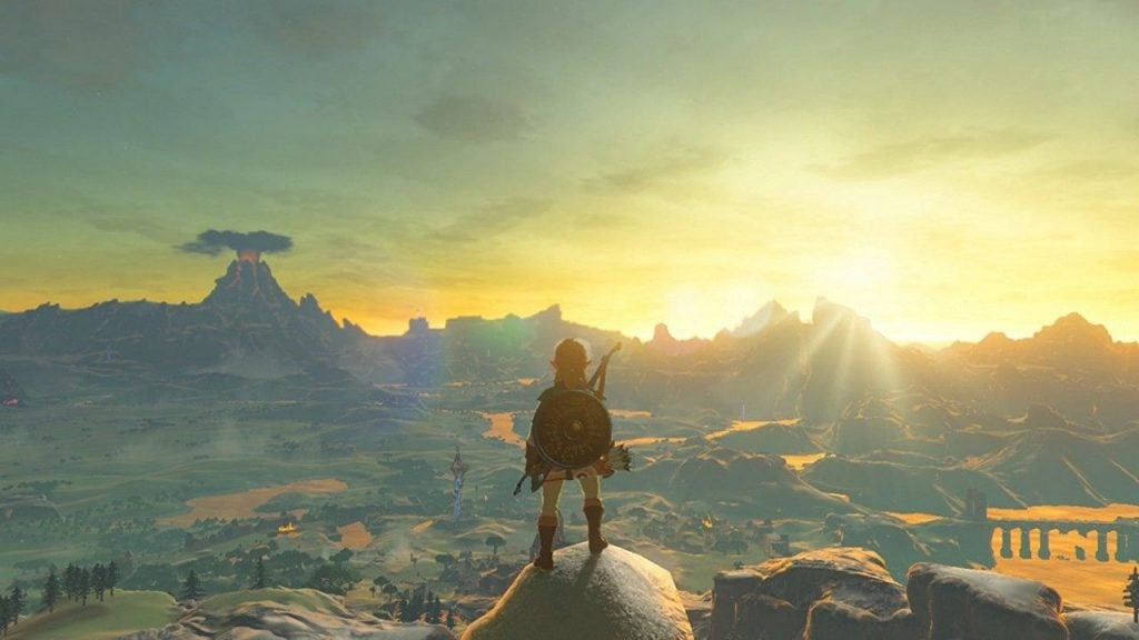 Link stands atop a mountain in Breath of the Wild