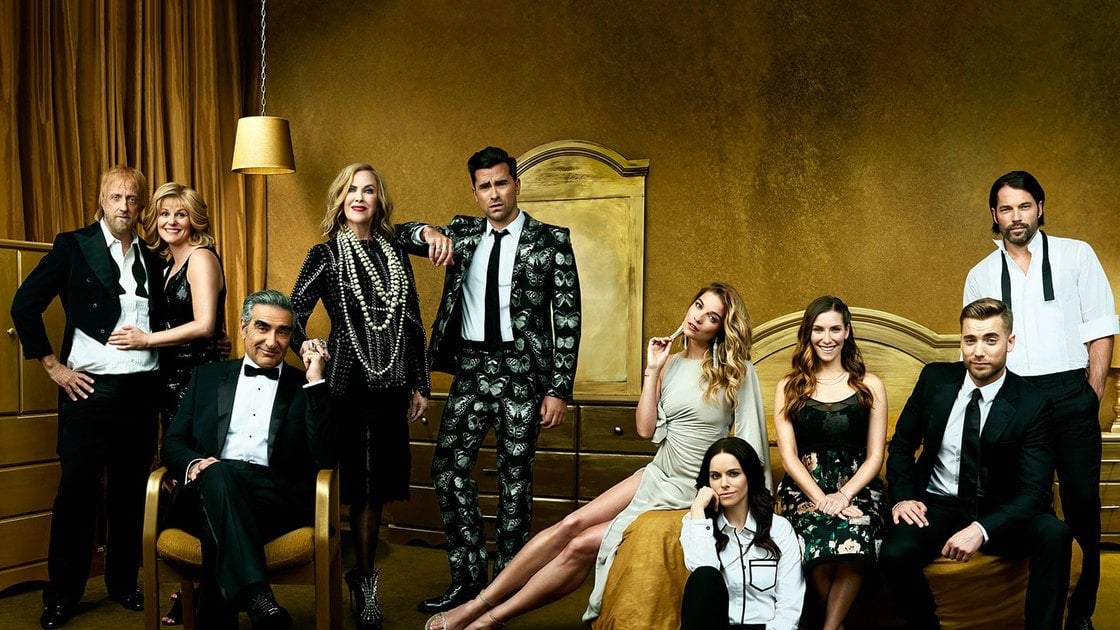 The cast of Schitt's Creek. pose in a bedroom