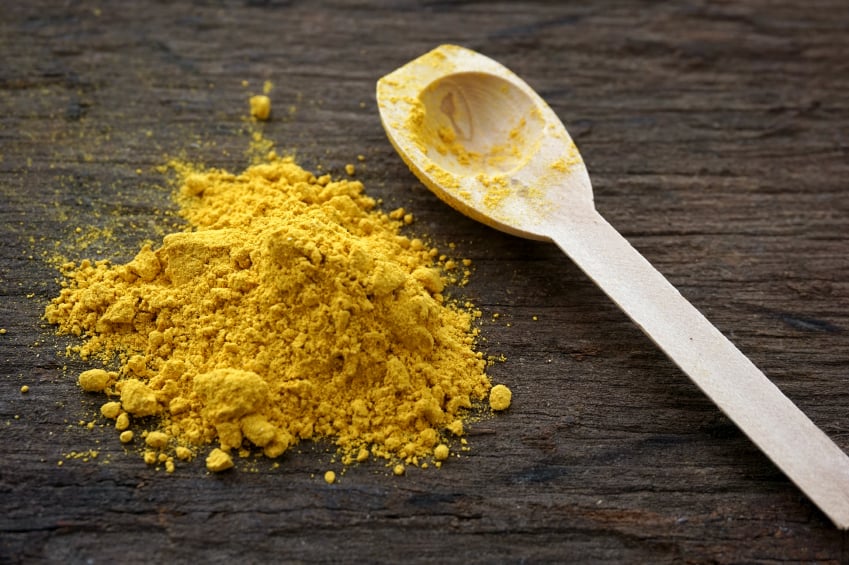 Turmeric on a table with a spoon Turmeric on a table with a spoon