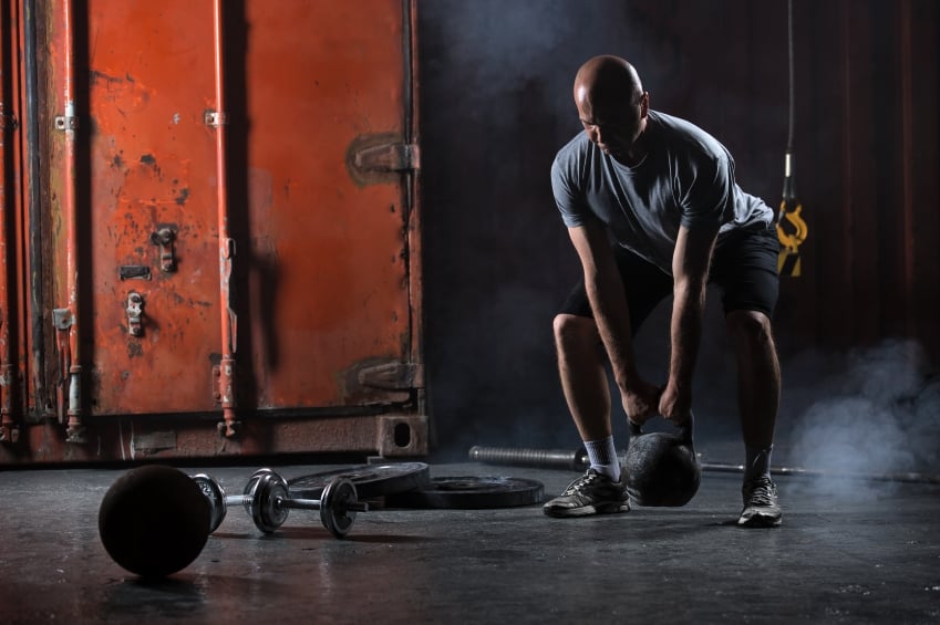 Man exercising with kettlebells