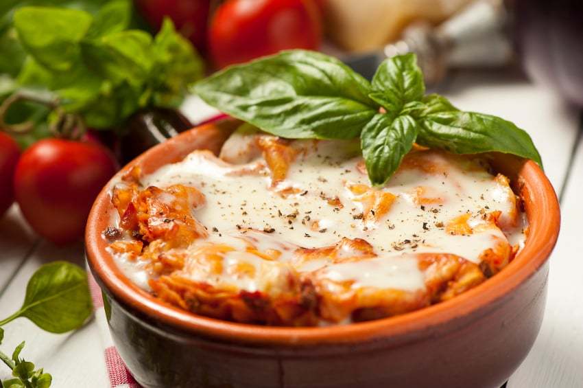 A small bowl of lasagna with fresh herbs