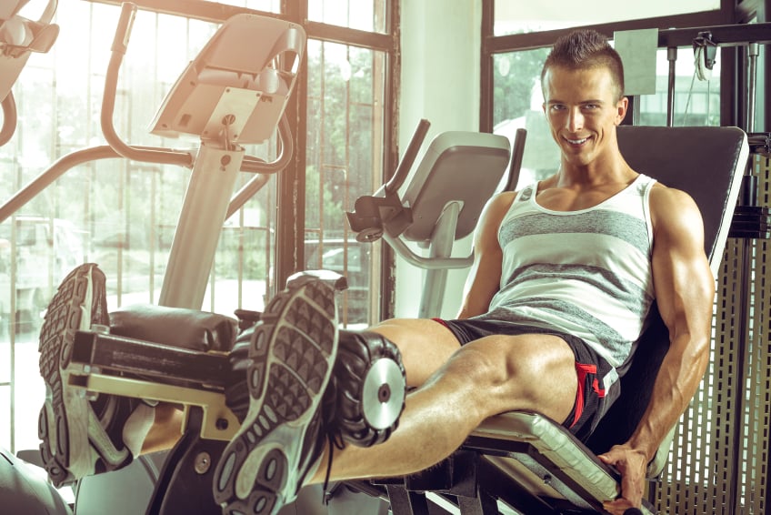 man doing leg extensions in the gym