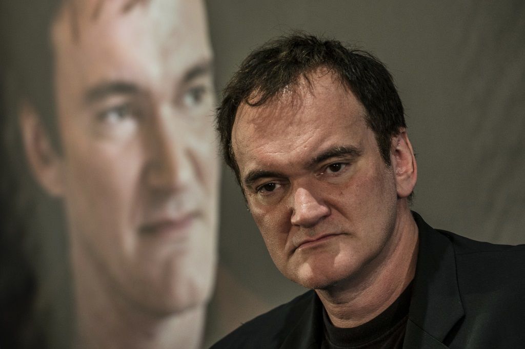 Quentin Tarantino in front of a photo of himself. Quentin Tarantino in front of a photo of himself.