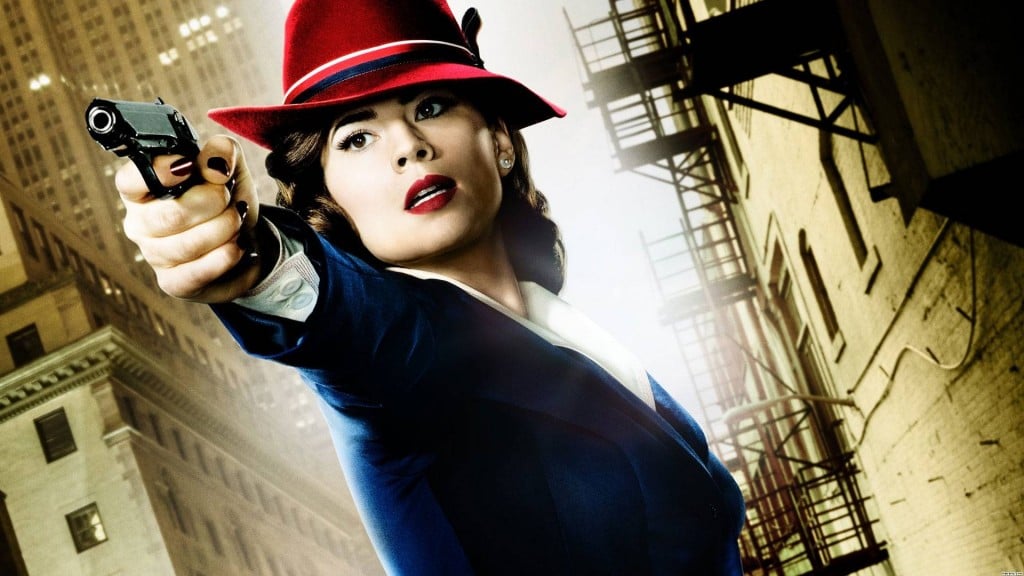 Hayley Atwell in a blue suit and red hat pointing a gun off-camera in Agent Carter poster art Hayley Atwell in a blue suit and red hat pointing a gun off-camera in Agent Carter poster art