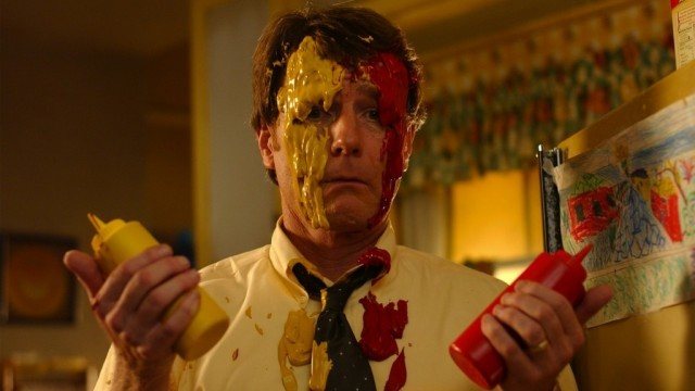 Hal holds a bottle of mustard and ketchup while smeared in both.