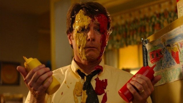 Hal holds a bottle of mustard and ketchup while smeared in both. Hal holds a bottle of mustard and ketchup while smeared in both.