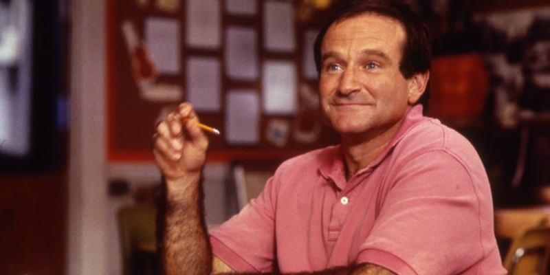 Robin Williams is wearing a pink shirt and holding up a pencil in Jack.