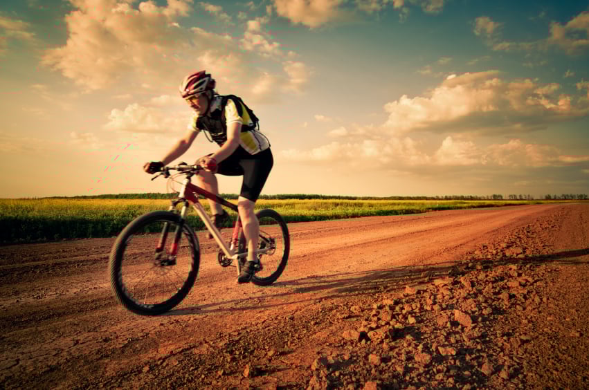 Man biking on a dirt road Man biking on a dirt road
