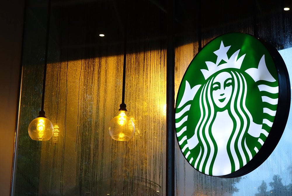 sign outside of a Starbucks coffee shop on a rainy day