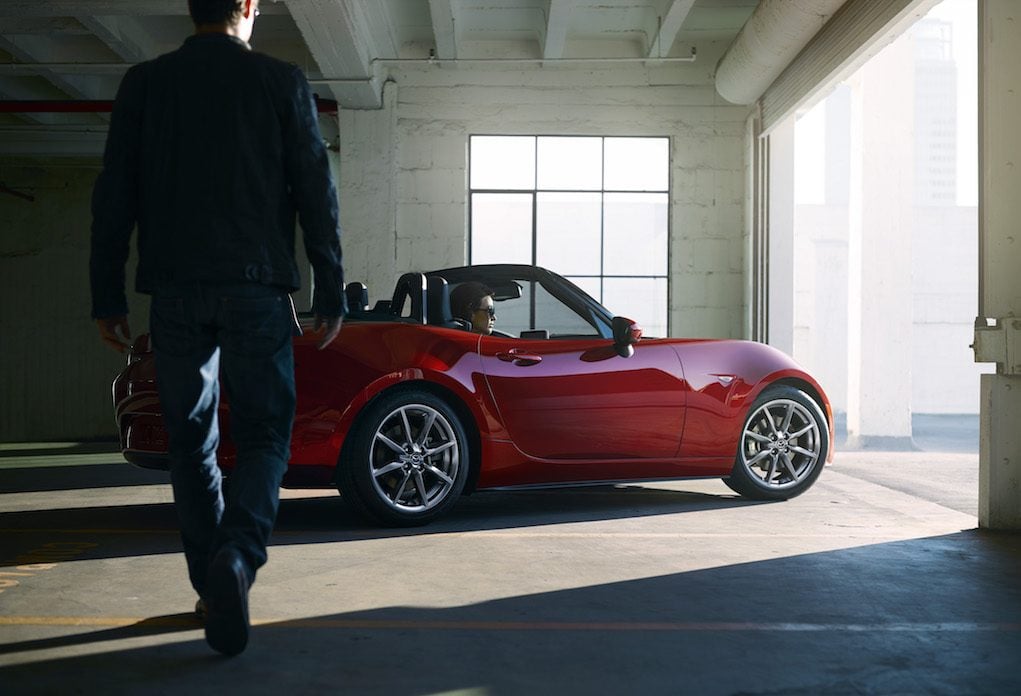 Drivers side profile view of red Mazda MX-5 Miata in garage