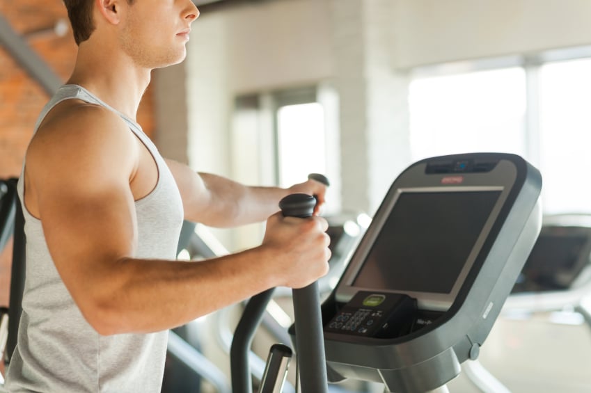 man working out on an elliptical trainer at the gym man working out on an elliptical trainer at the gym