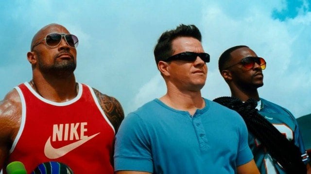 Dwayne Johnson, Mark Wahlberg and Anthony Mackie stand next to each other outdoors in 'Pain & Gain'