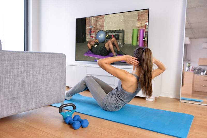 a woman on her yoga mat doing situps a woman on her yoga mat doing situps