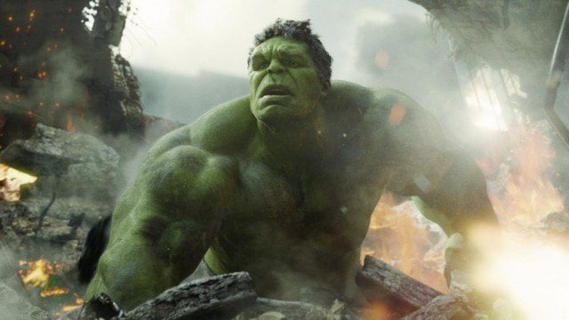 The Hulk in the middle off an explosion, looking off into the distance