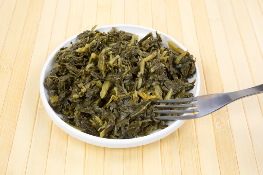 a serving of braised collard greens in a white bowl