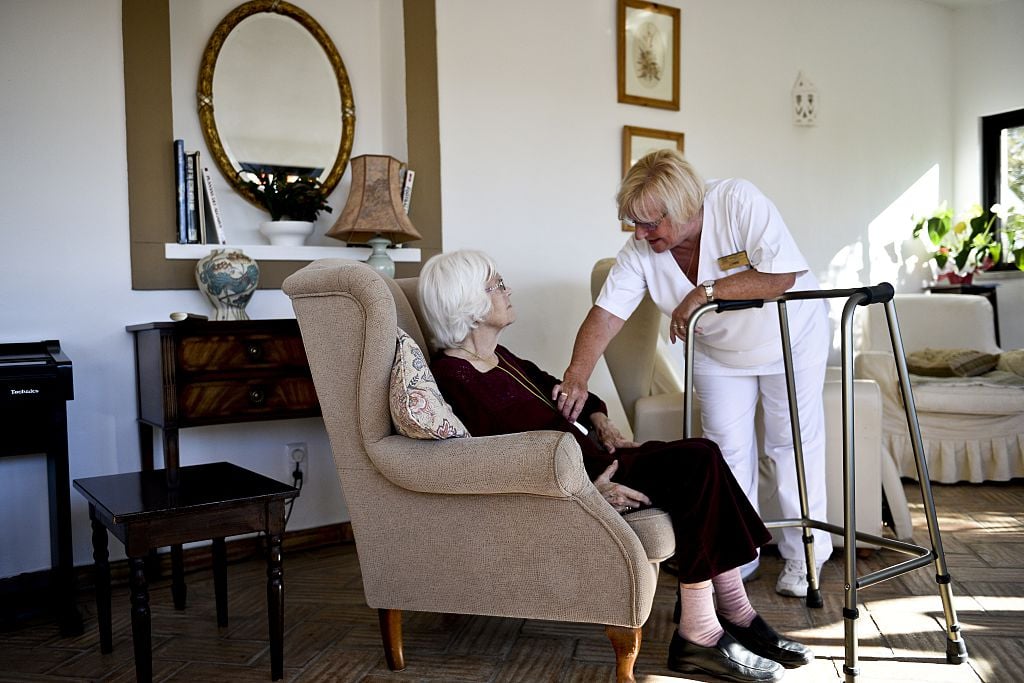 A social worker speaks to an old woman