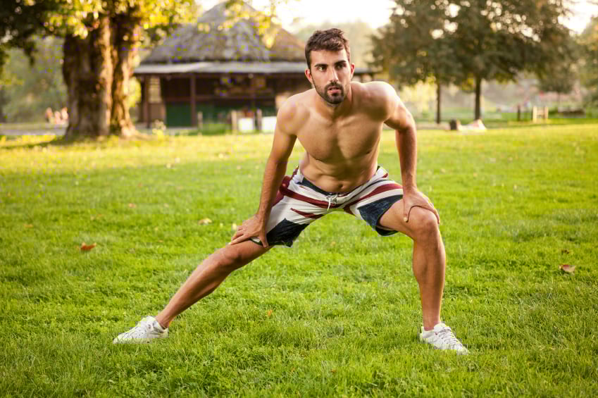 man performing side lunge or stretch in the park