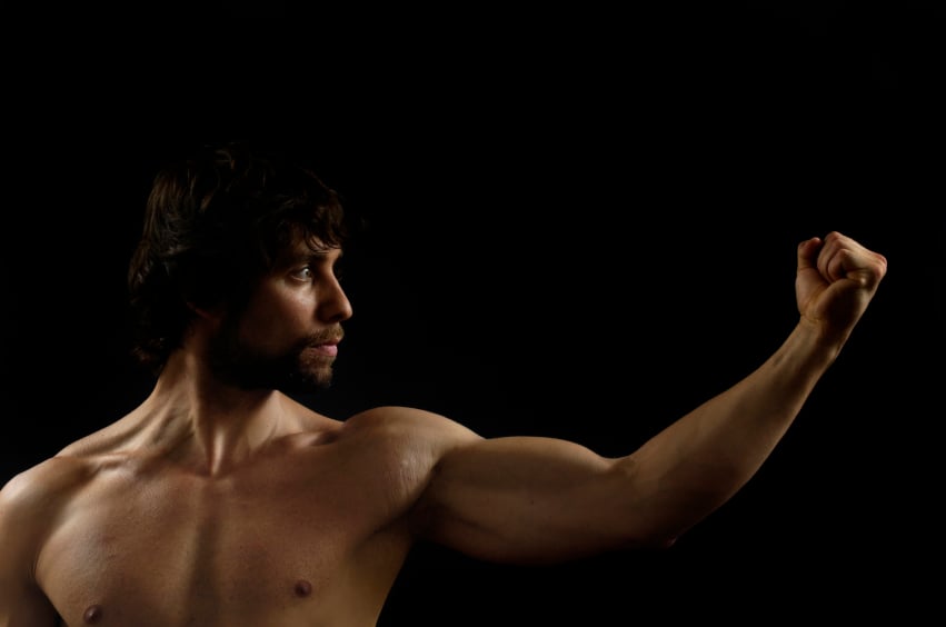 shirtless man flexing arm and posing