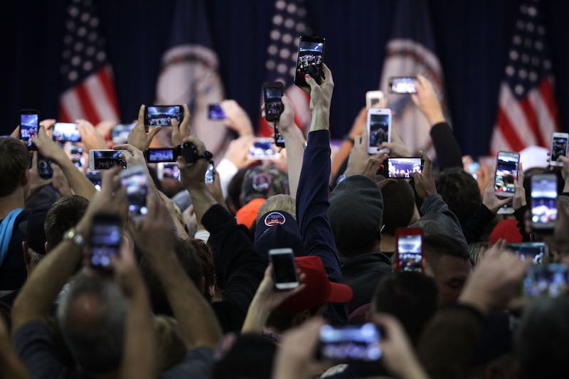 crowds wait with their phones to see Donald Trump at a rally