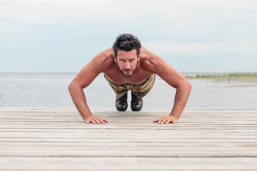 Man doing burpees on the beach