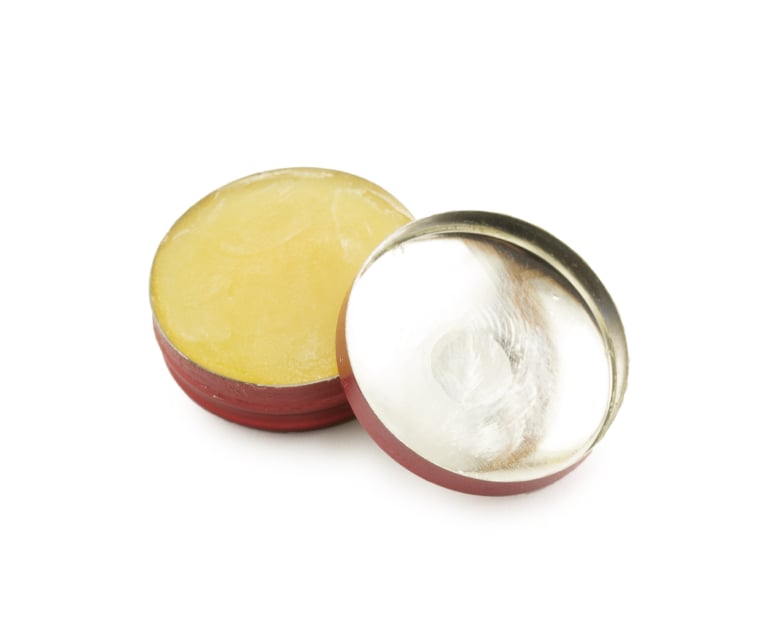 opened can of balm ointment on white background
