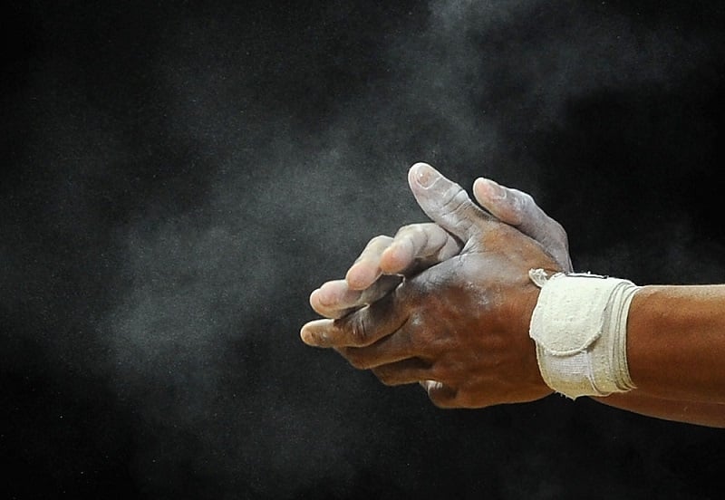 A man putting chalk on his hands A man putting chalk on his hands