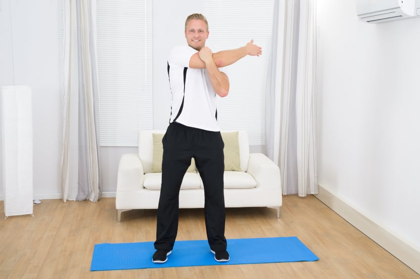 cheerful man doing exercise on mat