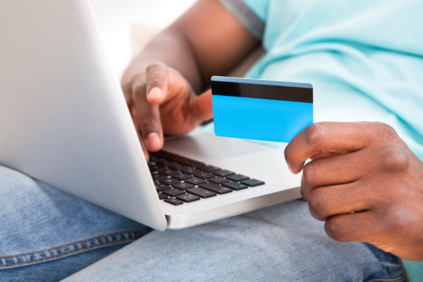 Young man using credit card on laptop