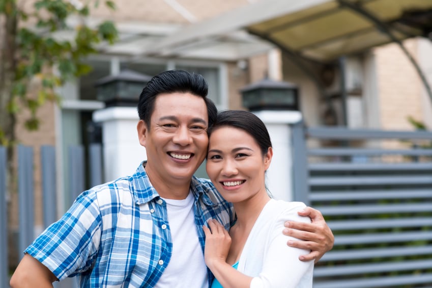 Happy couple outside their house
