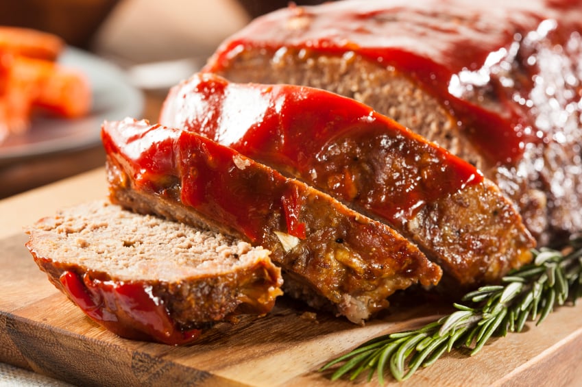 sliced meatloaf with ketchup glaze on a cutting board