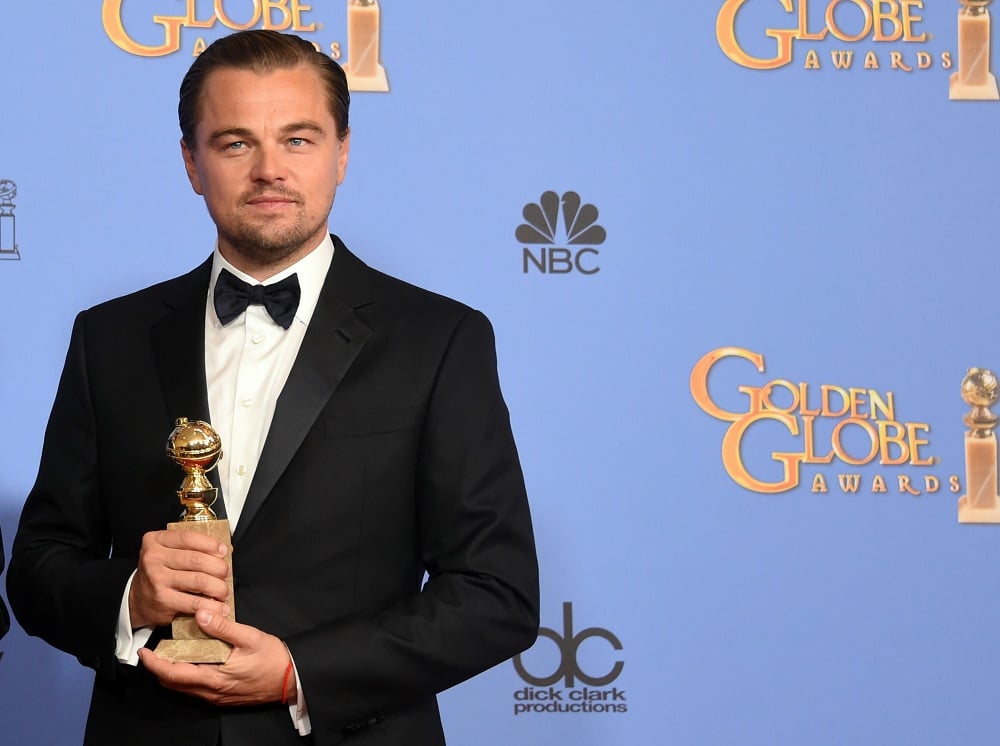 Leonardo DiCaprio is at the Golden Globes holding his award.