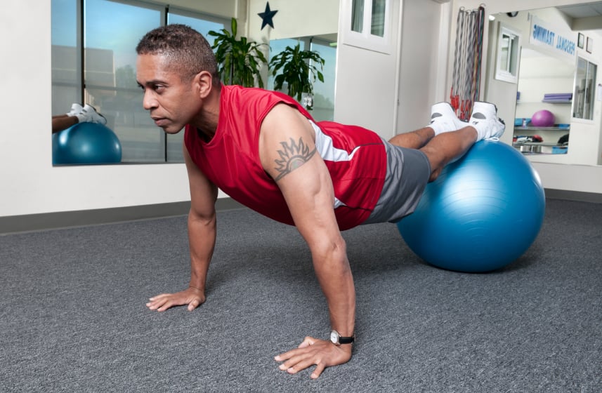 Man doing push ups on blue fitness ball Man doing push ups on blue fitness ball