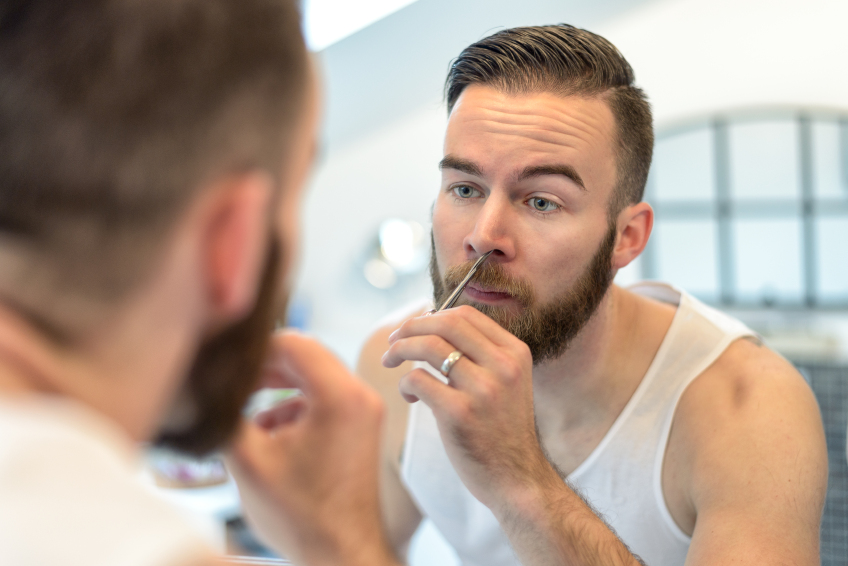man plucking his nasal hairs