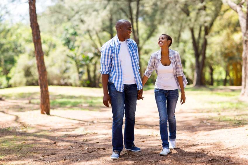 cheerful African American couple walking and looking at each other