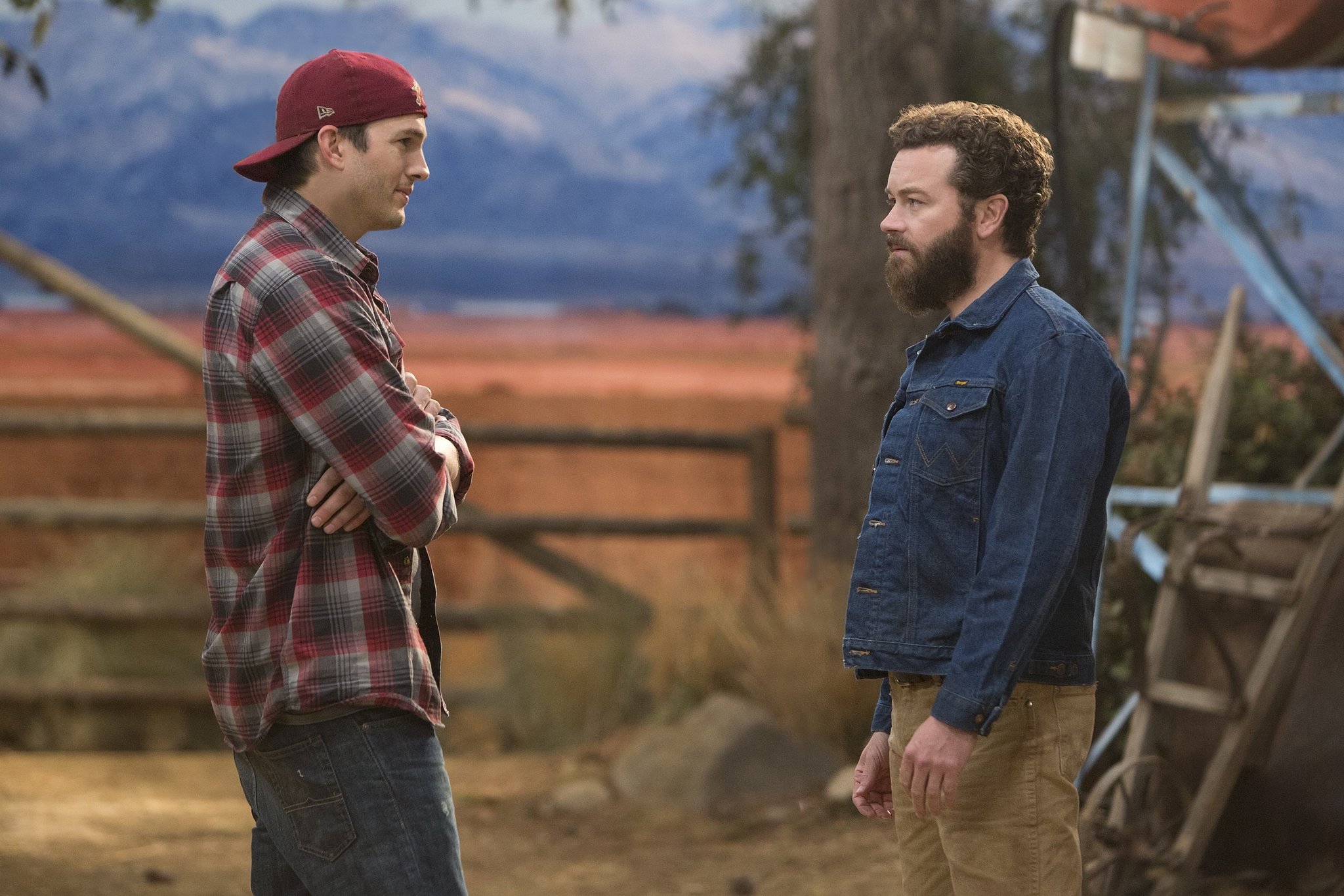 Ashton Kutcher and Danny Masterson talk to each other outside in The Ranch